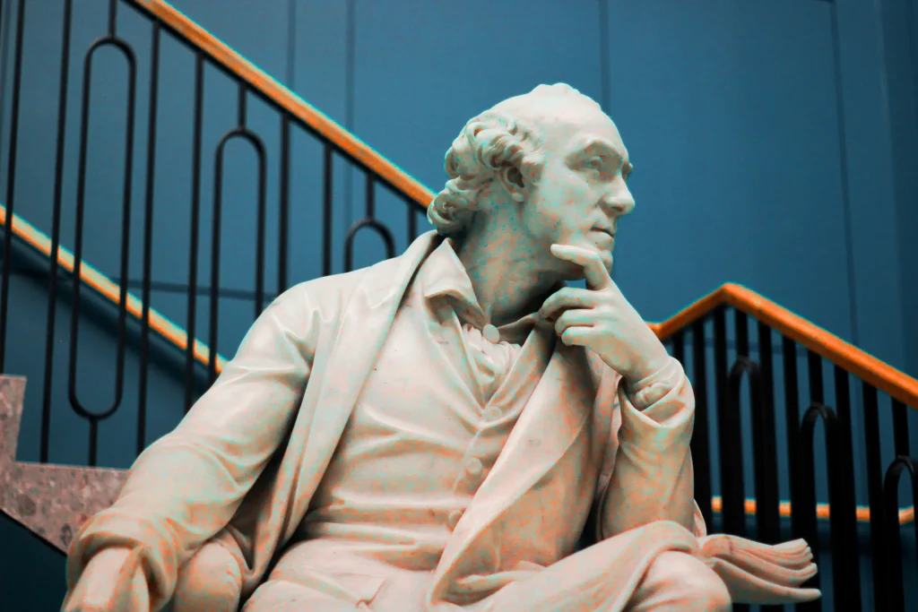 Marble statue holding documents on steps beside iron railings, a metaphor for it roadmap planning and direction.