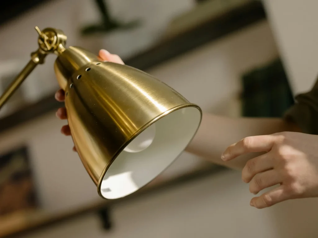 A hand holds a brass desk bell while an office workspace blurs in the background, symbolizing it governance models for mid sized organizations and technology adoption