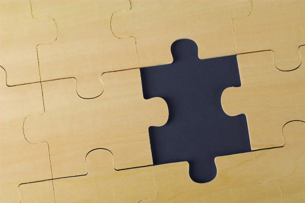 A dark puzzle piece fits into a beige jigsaw background, symbolizing IT roadmap planning and phased delivery.