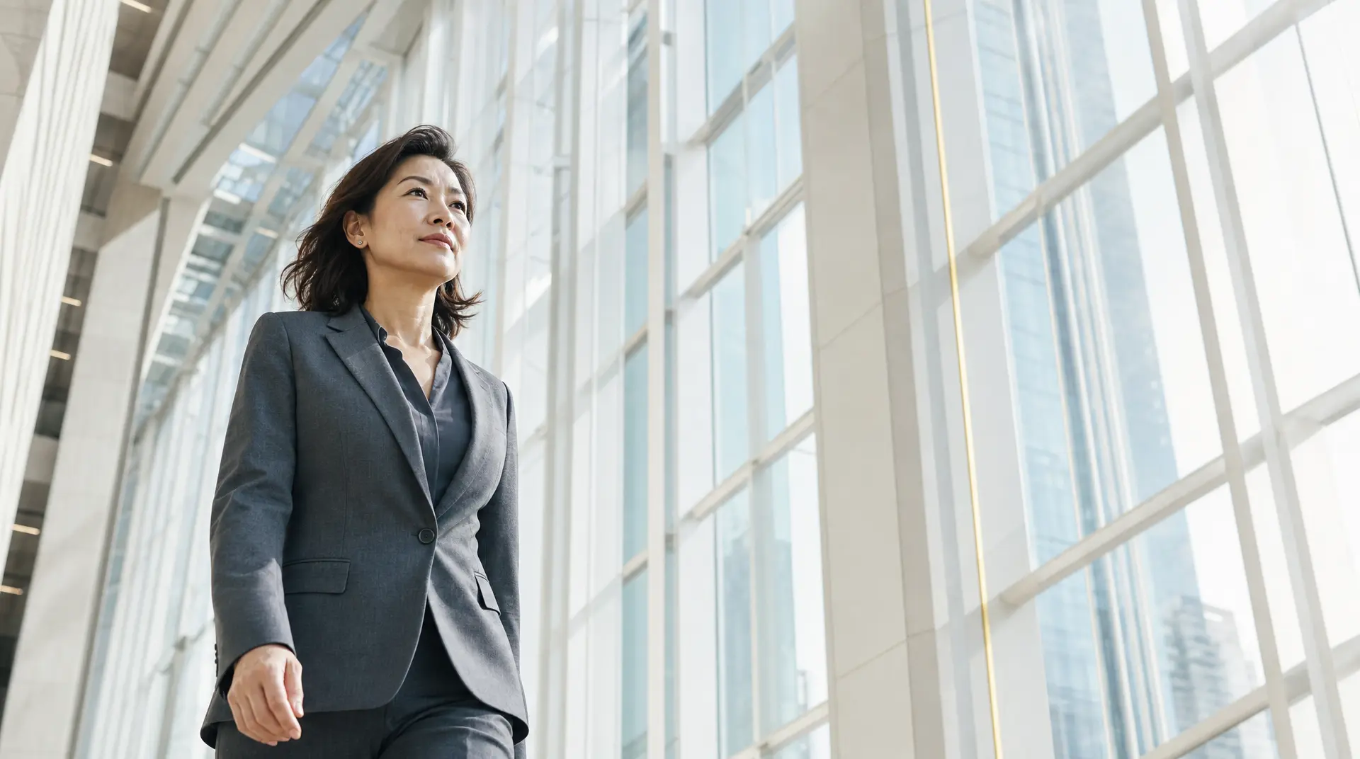 Business leader in a suit stands in a bright corporate atrium, aligning it spend with ebitda.