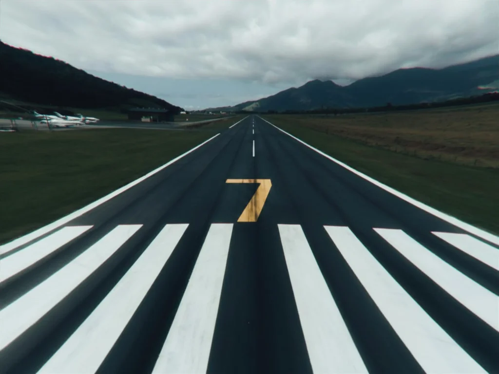 Long airport runway stretches forward under a cloudy sky toward a painted arrow, symbolizing an it roadmap.
