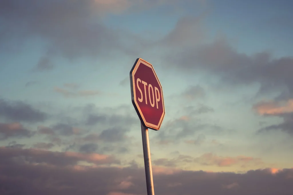 Red octagonal STOP sign against a cloudy sunset, calling for a pause in the technology investment roadmap.