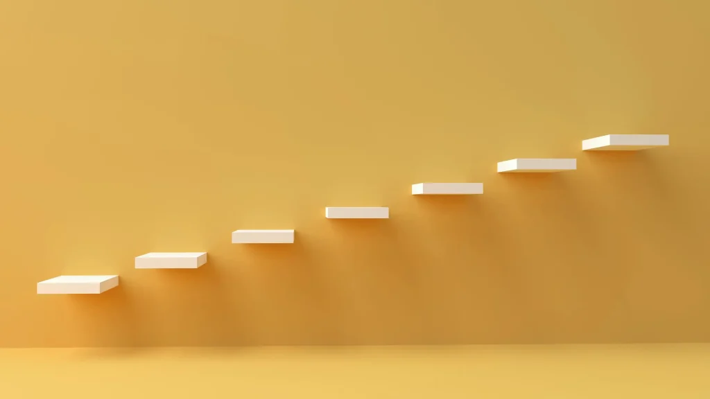 White step-like blocks rise diagonally across a warm yellow wall, signaling digital transformation consulting progress.